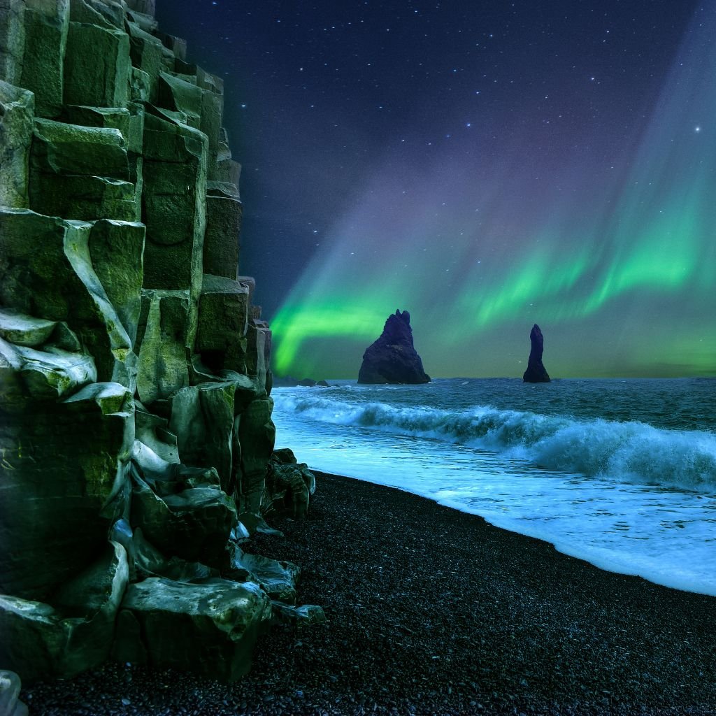 Aurora Boreal, na praia de areia negra, em Vik, Islândia